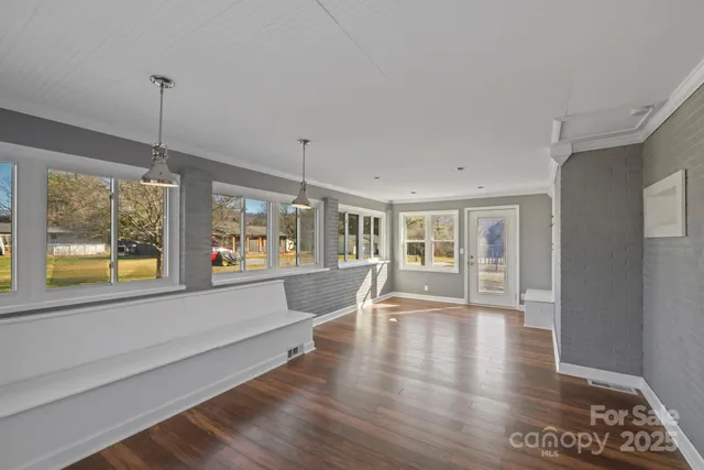 a large living room with hardwood floor and a view of kitchen