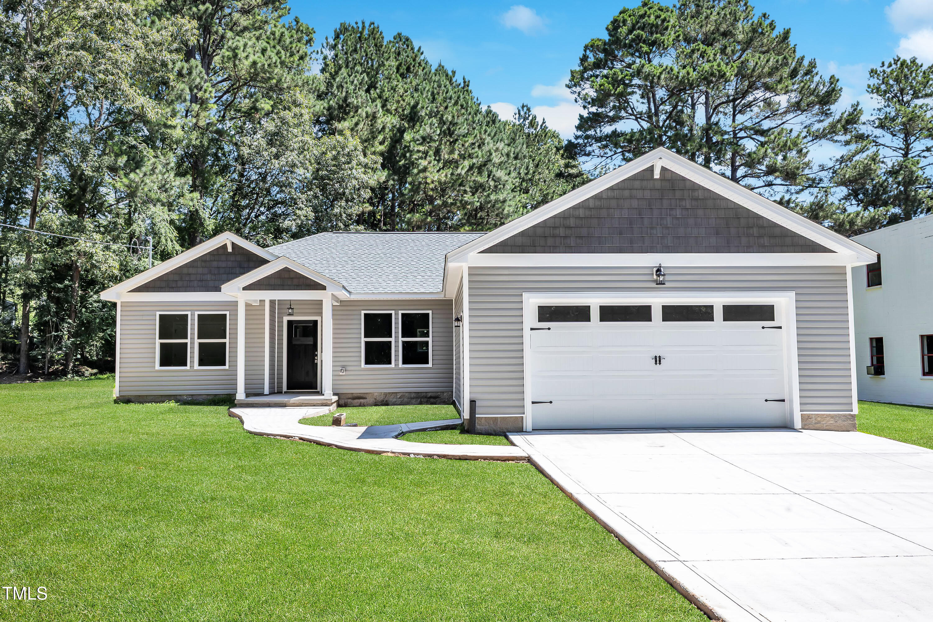 125 Davis Street Louisburg, NC 27549 - Photo 1 of 39 a front view of a house with a yard and trees