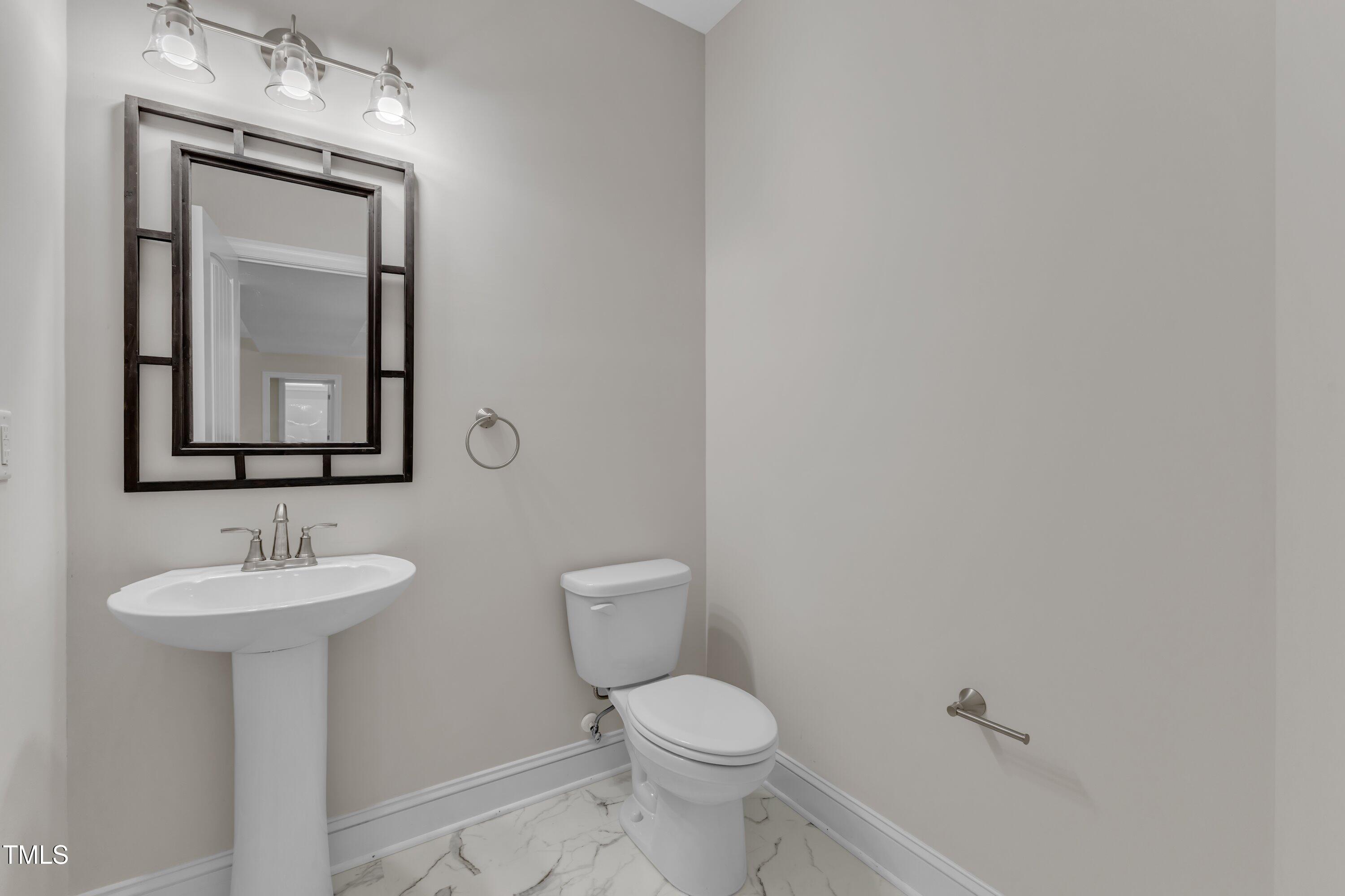 125 Davis Street Louisburg, NC 27549 - Photo 17 of 39 a bathroom with a toilet sink and mirror