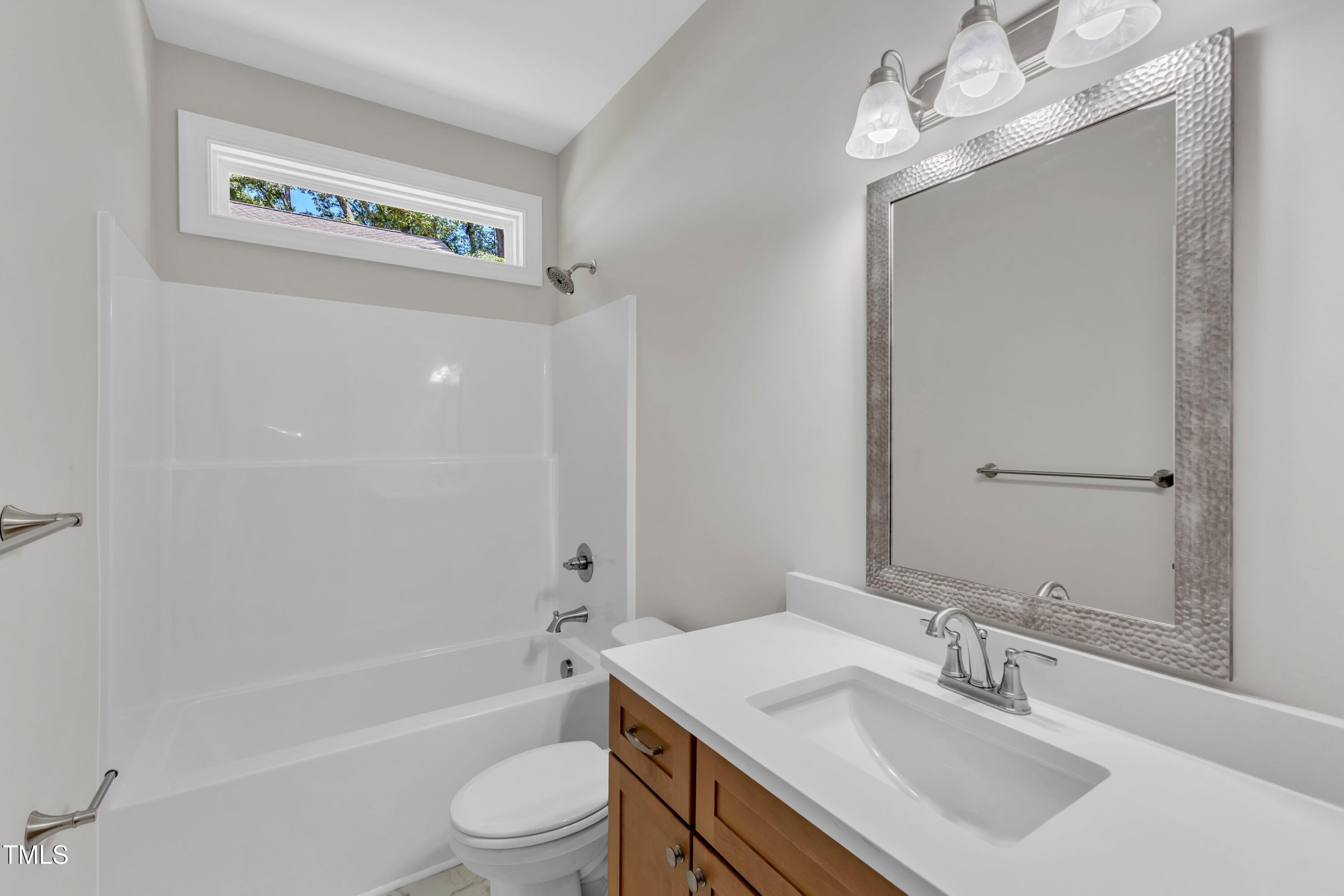 125 Davis Street Louisburg, NC 27549 - Photo 29 of 39 a bathroom with a sink a toilet a bathtub a mirror and shower