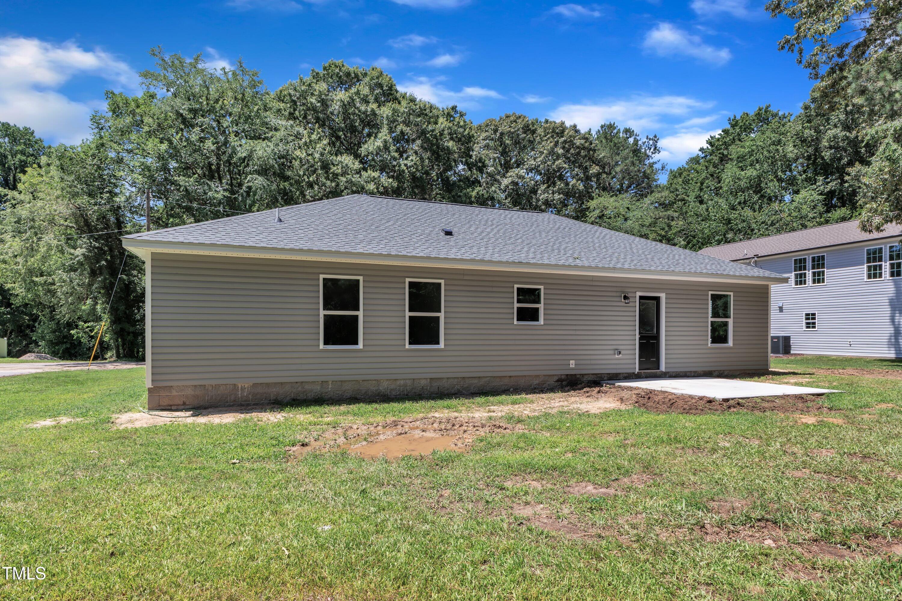 125 Davis Street Louisburg, NC 27549 - Photo 36 of 39 a house that is sitting in the grass with large trees