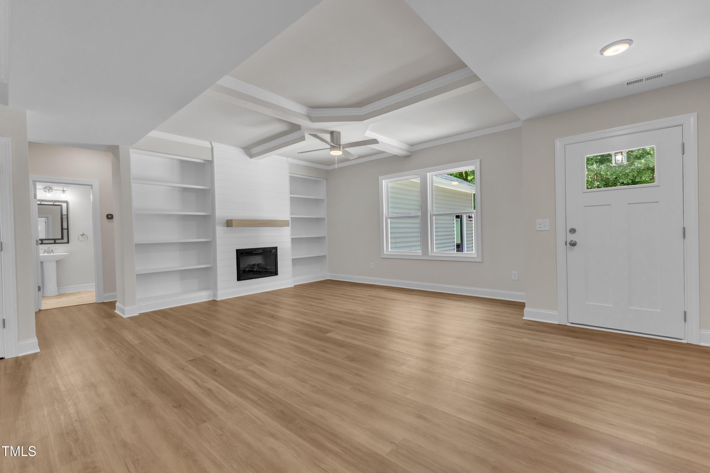 125 Davis Street Louisburg, NC 27549 - Photo 8 of 39 wooden floor in an empty room with a fireplace