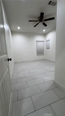 an empty room with fan and entrance