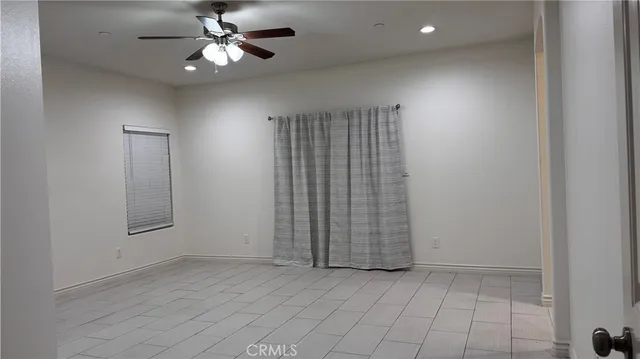 an empty room with chandelier fan