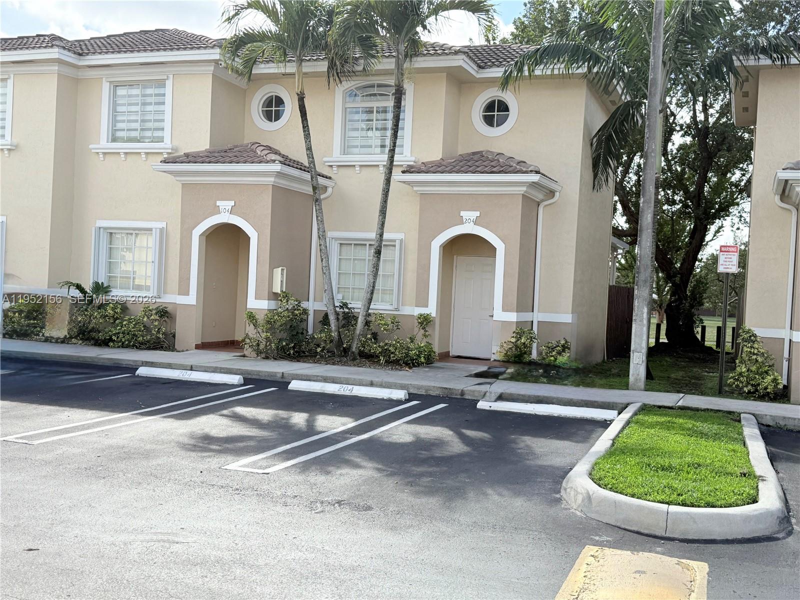 7330 Northwest 174th Terrace, Unit 204 Hialeah, FL 33015 - Photo 1 of 18 a front view of a house with a yard