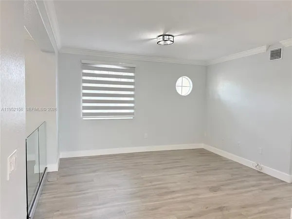 a view of a room with wooden floor and window