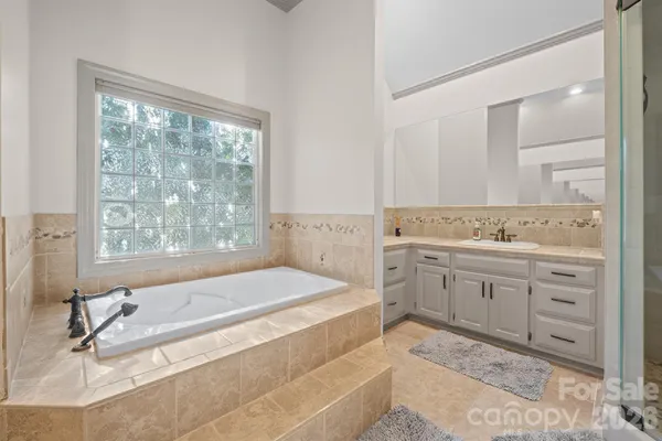 a spacious bathroom with a granite countertop tub sink and mirror
