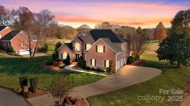 an aerial view of residential houses with outdoor space and trees