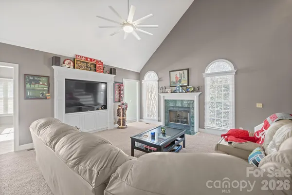 a living room with furniture a fireplace and a flat screen tv