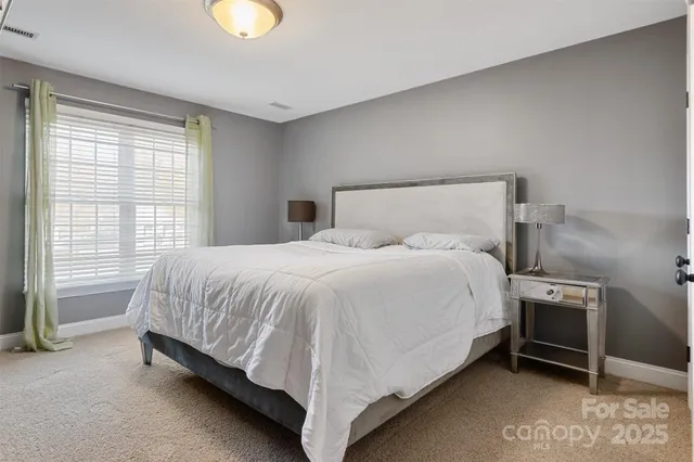 a bed sitting in a bedroom next to a window