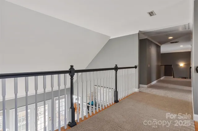 a view of staircase with lots of frames on wall and stairs