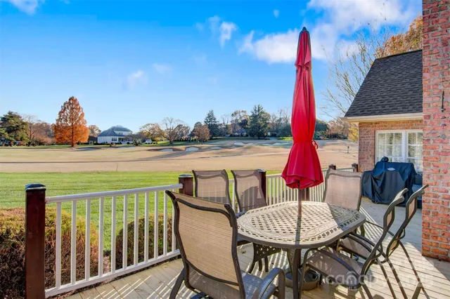 a view of a patio with a table chairs and a wooden deck
