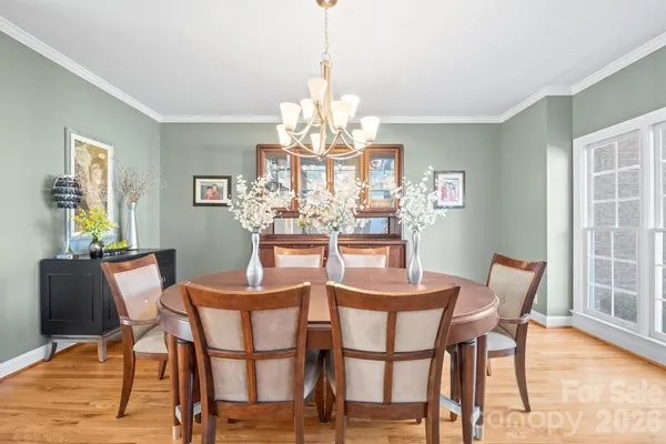 a dining room filled chandelier and wooden floor