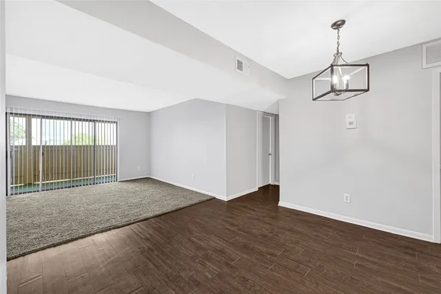 a view of empty room with wooden floor and ceiling fan