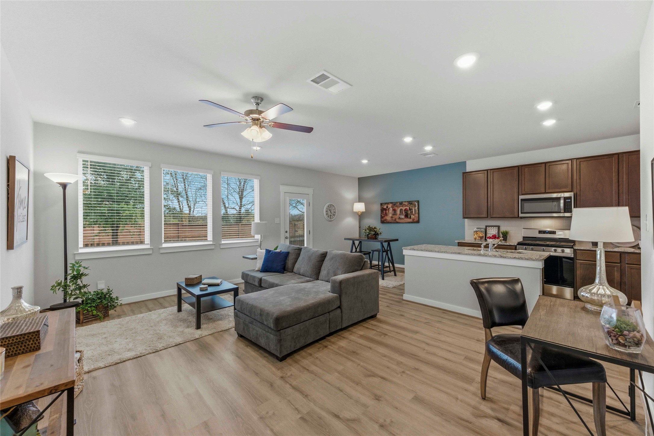 a living room with furniture kitchen view and a large window