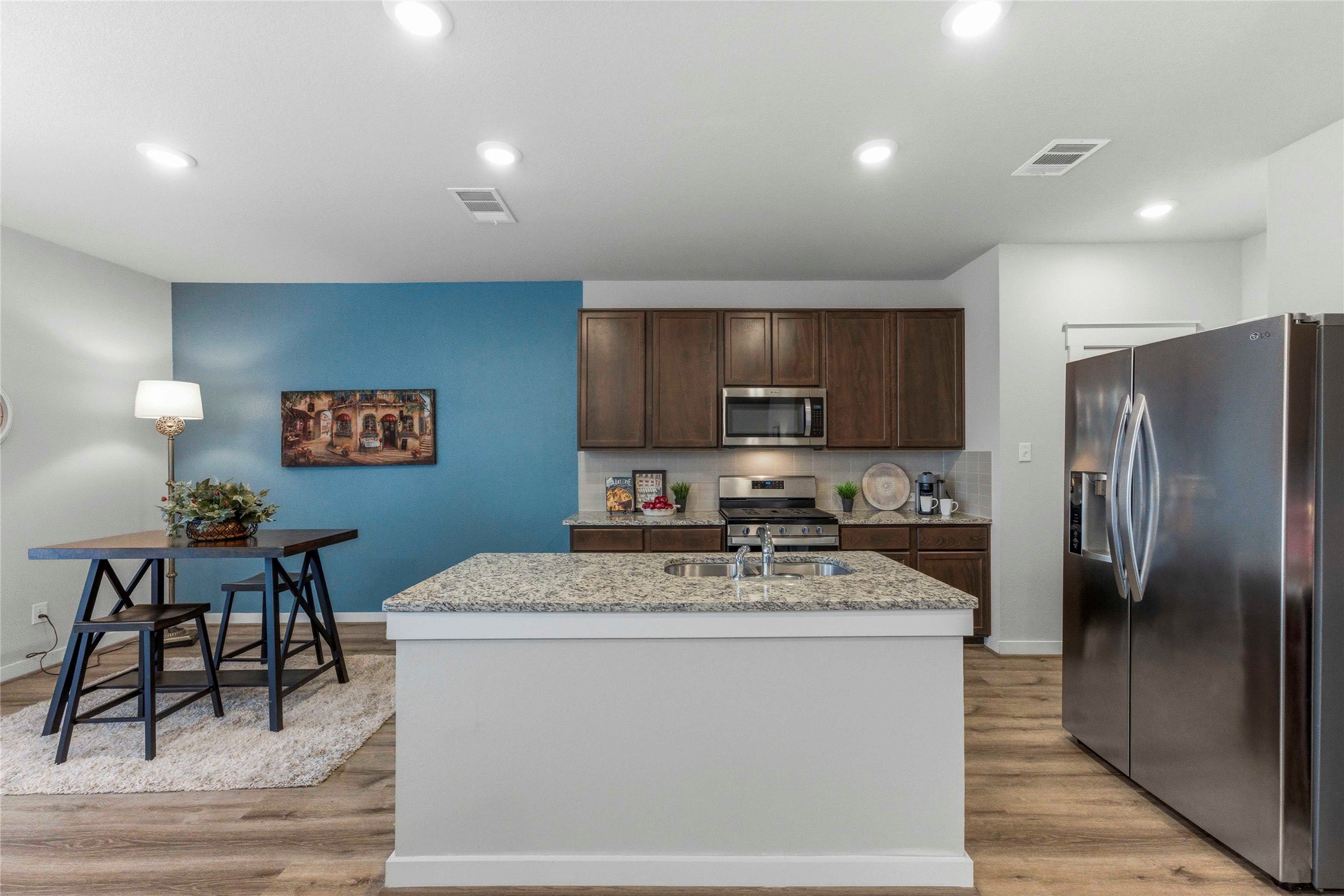 17203 Leafroller Drive, Unit B Pflugerville, TX 78660 - Photo 7 of 20 a kitchen with stainless steel appliances a refrigerator stove microwave and sink