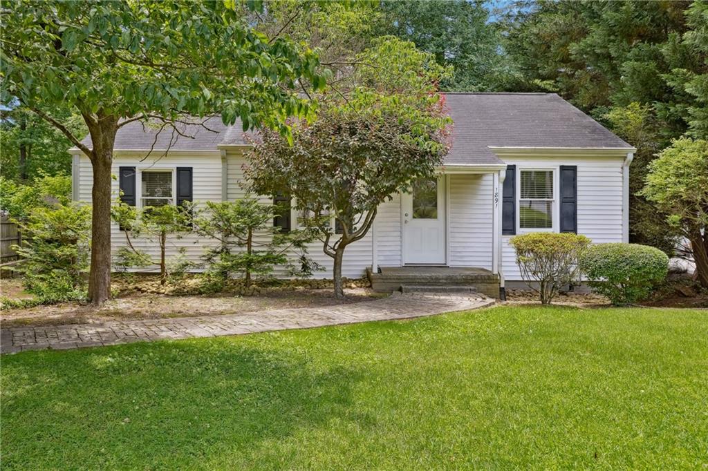 a front view of a house with a garden and yard