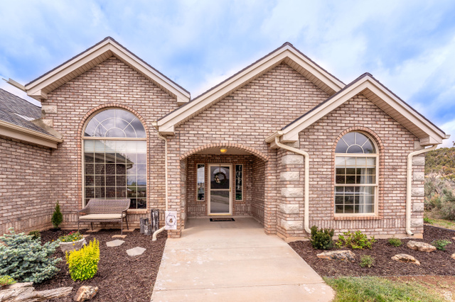 7343 North Sawtooth Cv Road Vernal, UT 84078 - Photo 53 of 64 Brick exterior featuring gabled rooflines, arched entry, and complementary stone accents