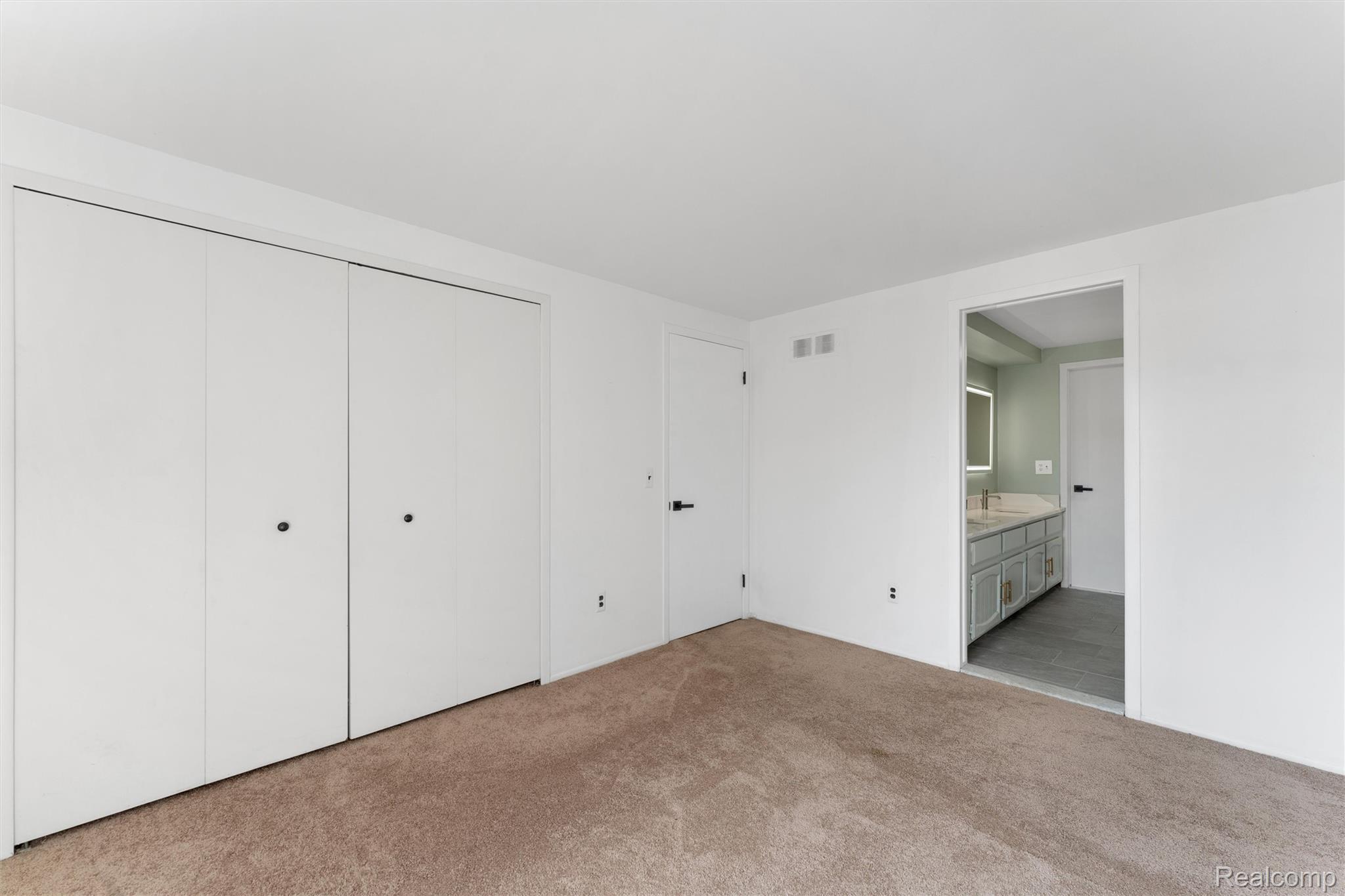 32105 West 12 Mile Road Farmington, MI 48334 - Photo 24 of 39 Unfurnished bedroom featuring a closet, ensuite bath, and light carpet