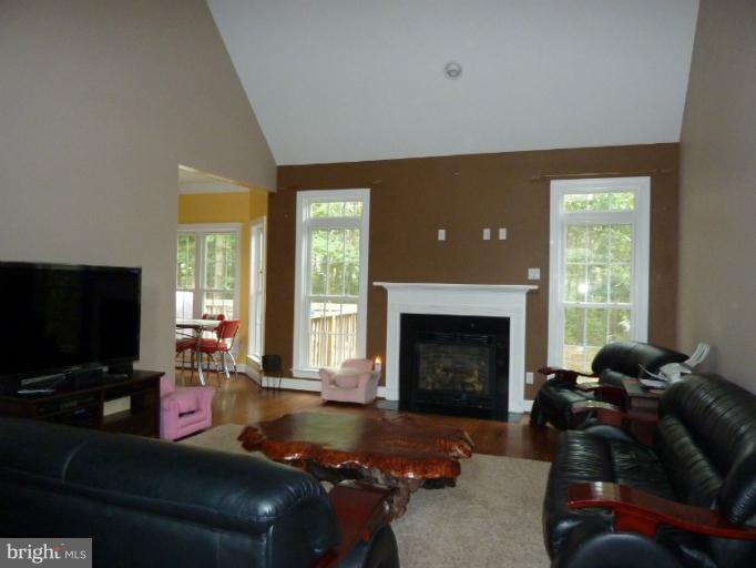 168 Holiday Road Cross Junction, VA 22625 - Photo 22 of 29 a living room with furniture a fireplace and a flat screen tv