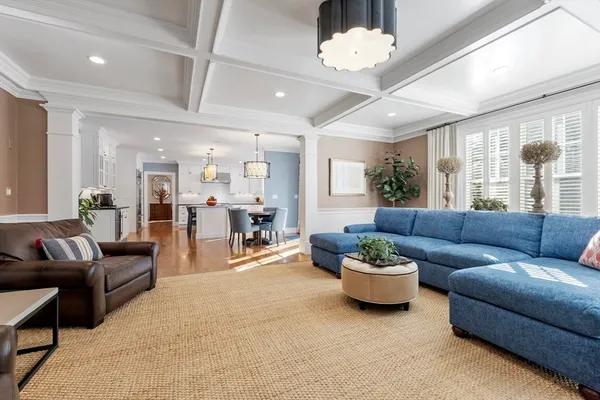 a living room with furniture a chandelier and a view of kitchen