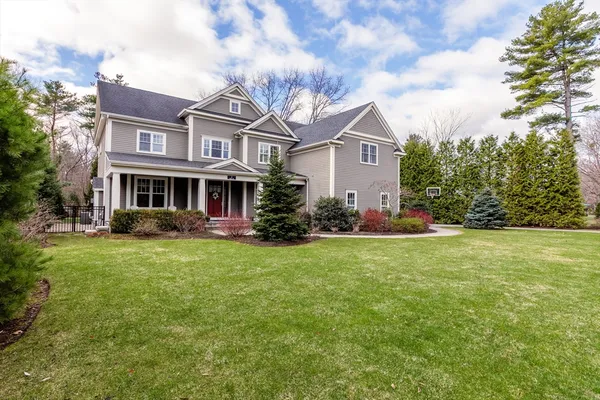 a front view of house with yard and trees all around