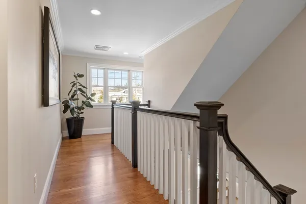 a view of a hallway with the entryway and wooden floor