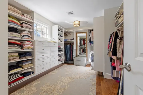 a view of walk in closet with clothes and shoes