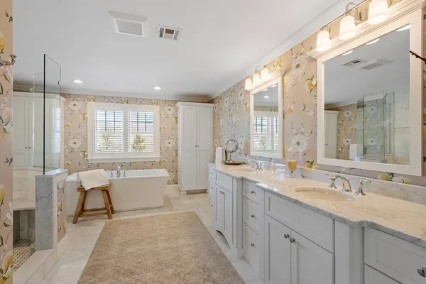 a spacious bathroom with a double vanity sink large mirror and a bathtub
