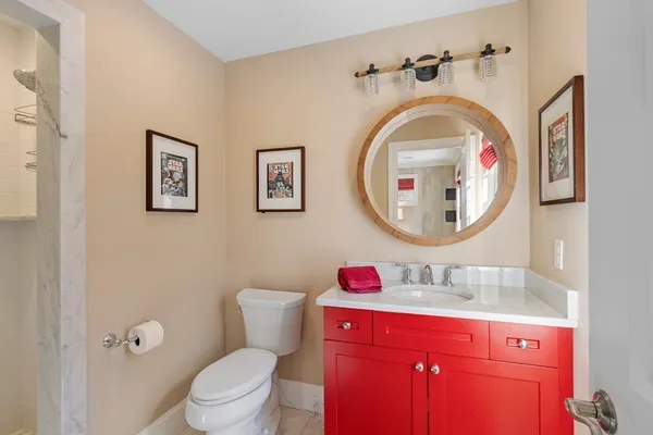 a bathroom with a toilet sink vanity and mirror