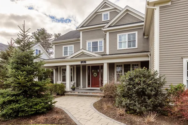 a view of a white house with large windows and a small yard