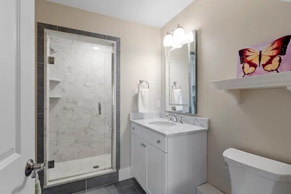 a bathroom with a sink a toilet and shower