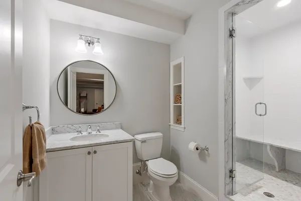 a bathroom with a toilet sink and mirror