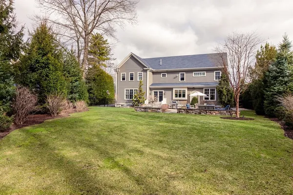 a view of a big house with a big yard and large trees