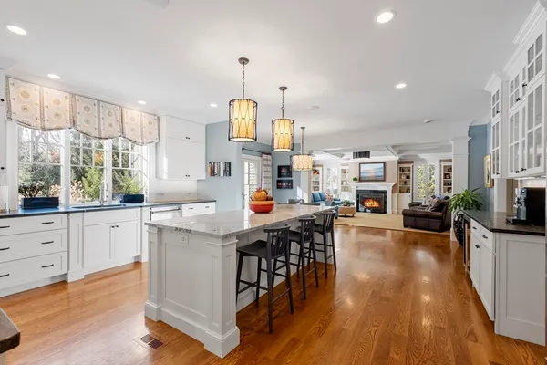 a kitchen with stainless steel appliances a table chairs refrigerator microwave and a sink