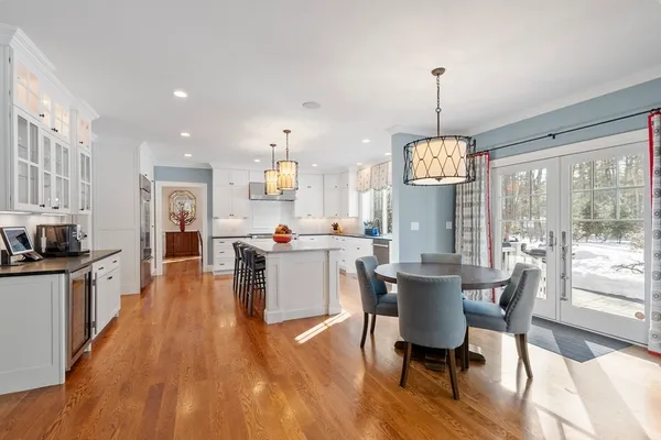 a view of a dining room and livingroom with furniture wooden floor a chandelier