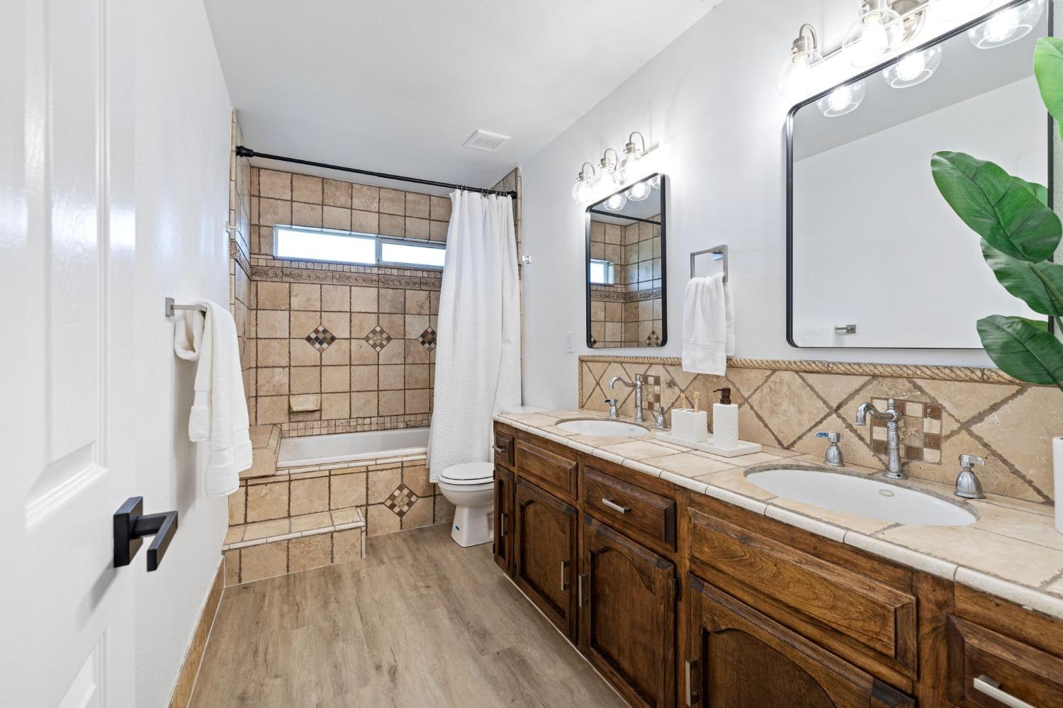 17153 Rodeo Drive Madera, CA 93638 - Photo 13 of 22 a spacious bathroom with a double vanity sink a mirror and a shower