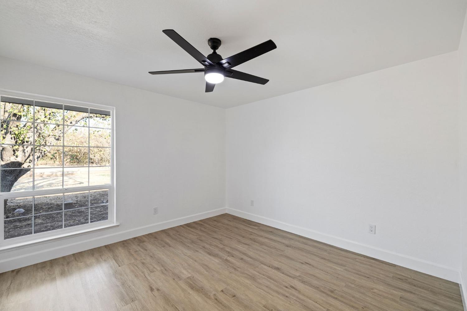 17153 Rodeo Drive Madera, CA 93638 - Photo 14 of 22 wooden floor in an empty room with a window