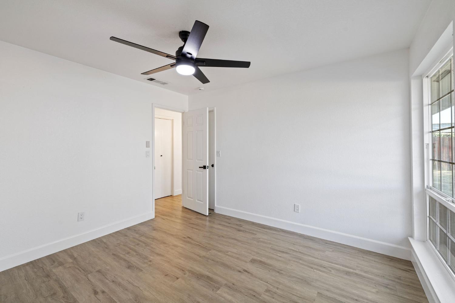 17153 Rodeo Drive Madera, CA 93638 - Photo 15 of 22 a view of empty room with wooden floor and fan