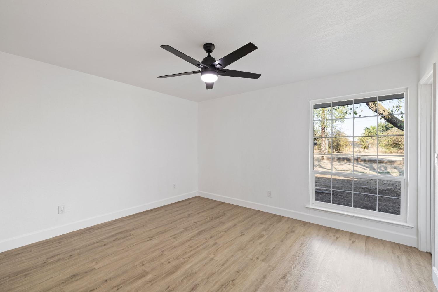 17153 Rodeo Drive Madera, CA 93638 - Photo 16 of 22 a view of an empty room with wooden floor and a window