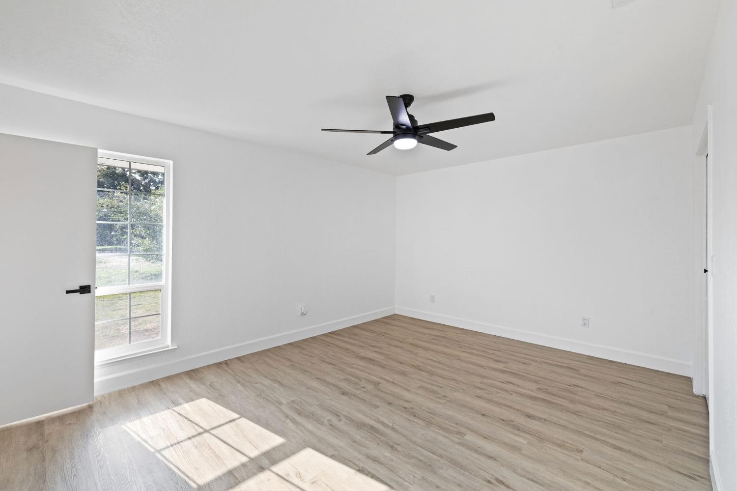 17153 Rodeo Drive Madera, CA 93638 - Photo 18 of 22 an empty room with wooden floor and windows