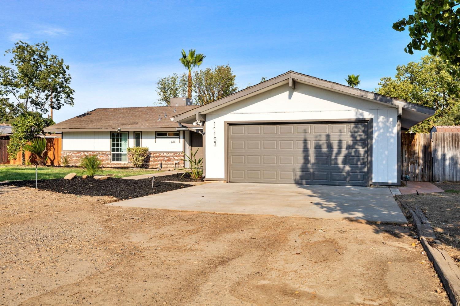 17153 Rodeo Drive Madera, CA 93638 - Photo 2 of 22 a front view of a house with a yard and garage