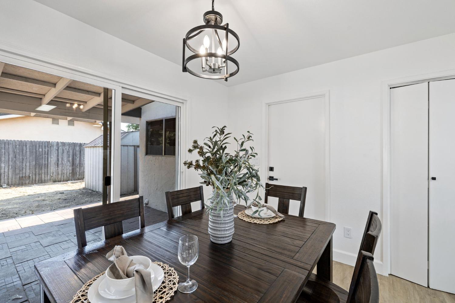 17153 Rodeo Drive Madera, CA 93638 - Photo 8 of 22 a view of a dining room with furniture a chandelier and wooden floor