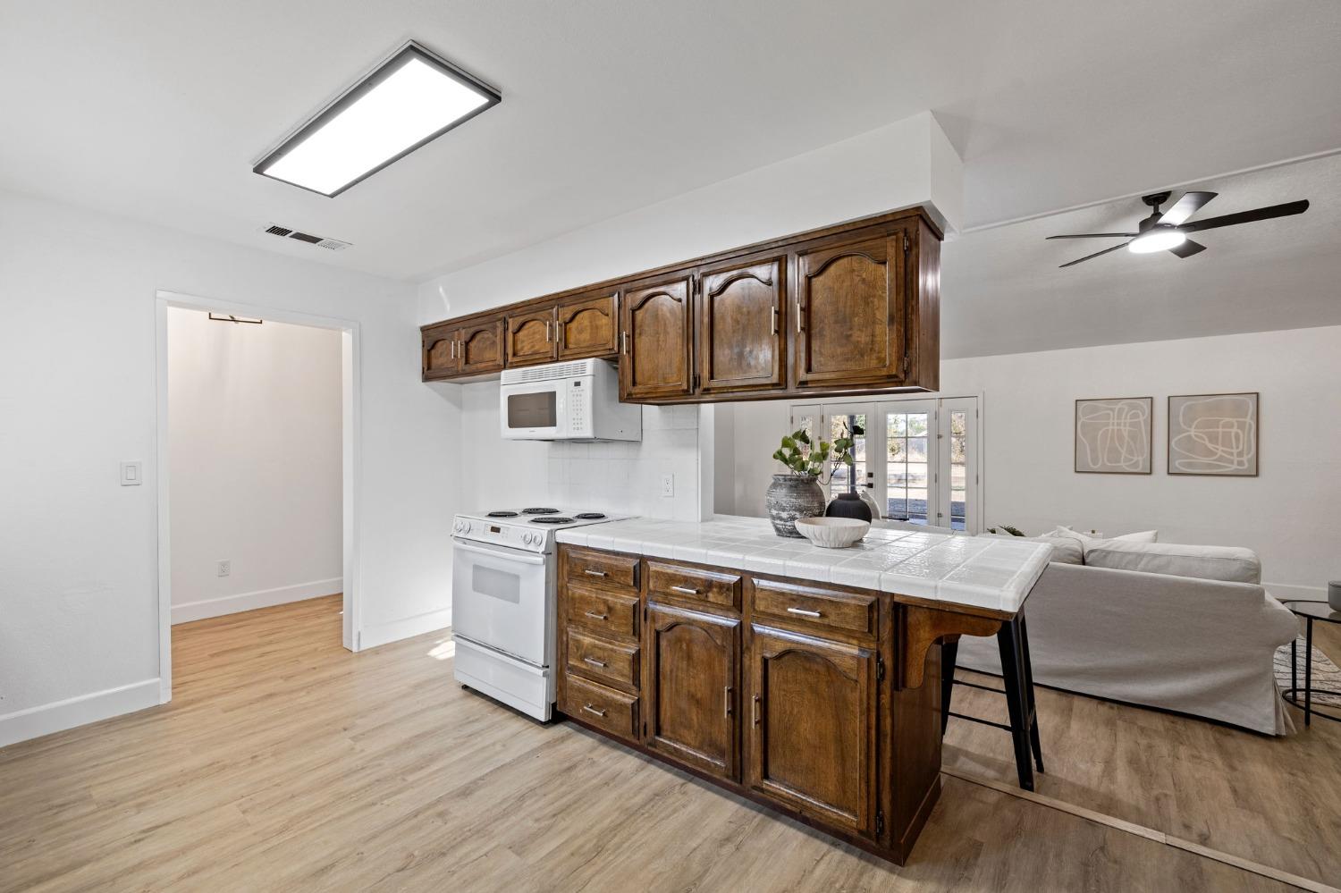17153 Rodeo Drive Madera, CA 93638 - Photo 10 of 22 a kitchen with stainless steel appliances granite countertop a sink dishwasher stove and oven with wooden floor