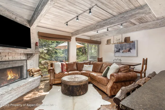 a living room with furniture a flat screen tv and a fireplace
