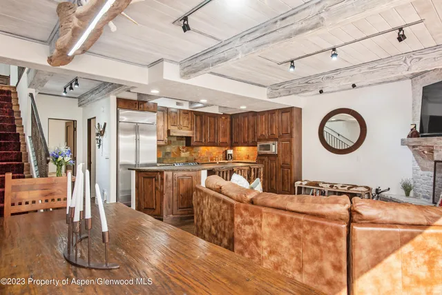 a living room with stainless steel appliances granite countertop furniture and a kitchen view