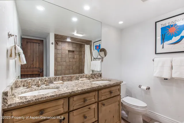 a bathroom with a granite countertop sink a toilet and a mirror