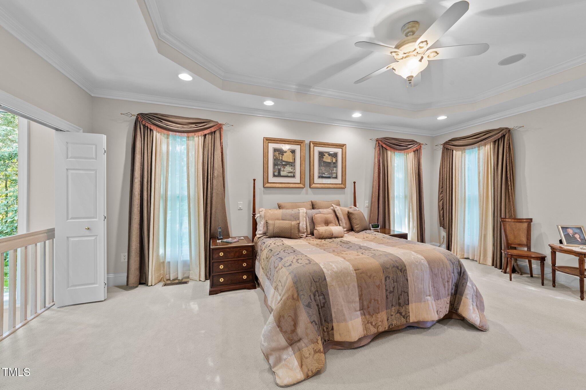 12504 Bayleaf Church Road Raleigh, NC 27614 - Photo 20 of 73 a spacious bedroom with a large bed and a chandelier