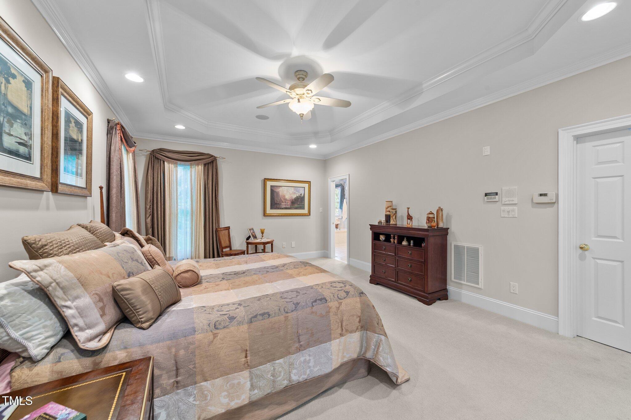 12504 Bayleaf Church Road Raleigh, NC 27614 - Photo 21 of 73 a spacious bedroom with a bed and a chandelier