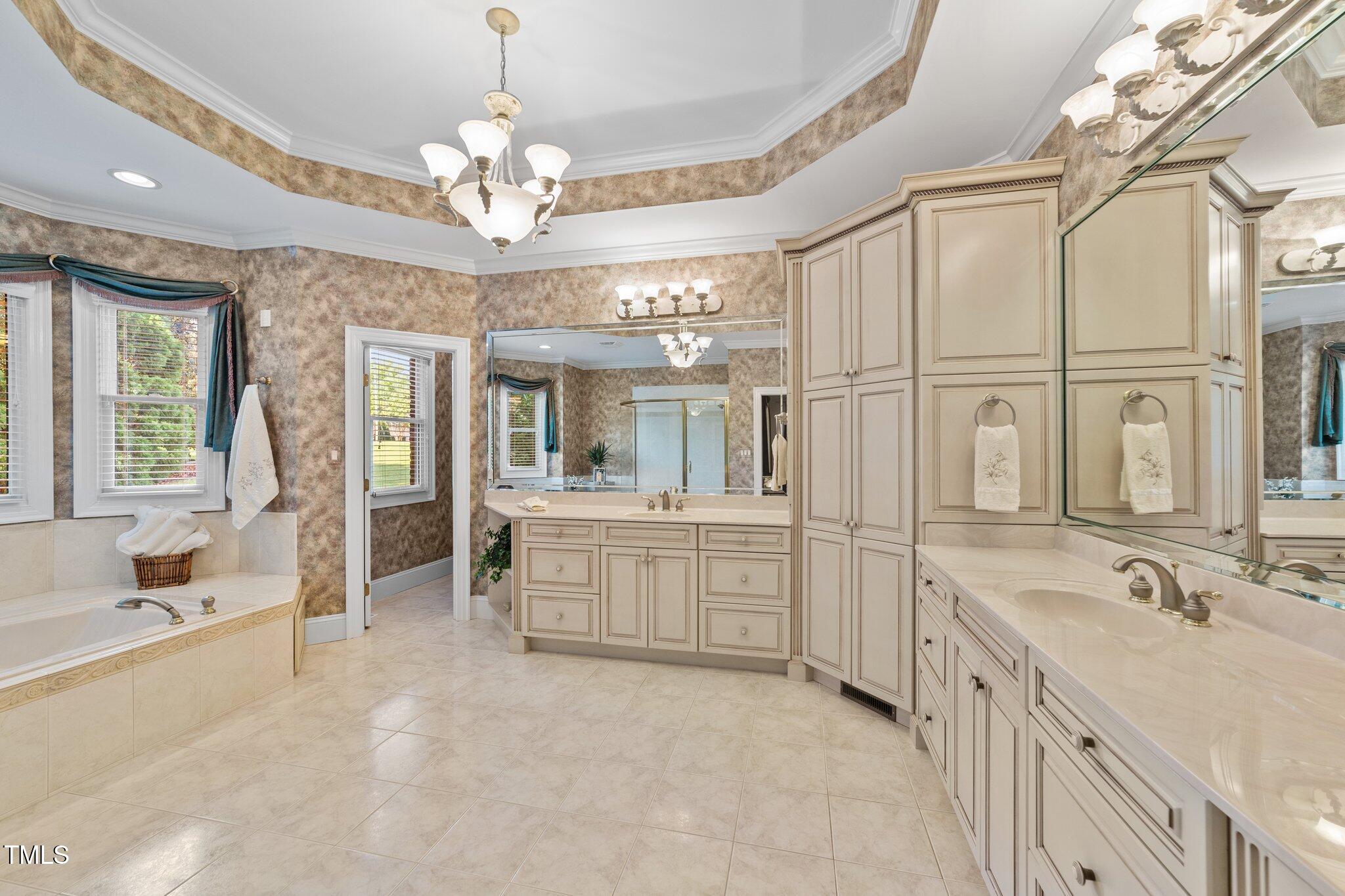 12504 Bayleaf Church Road Raleigh, NC 27614 - Photo 26 of 73 a spacious bathroom with a granite countertop sink a large mirror and a bathtub with shower
